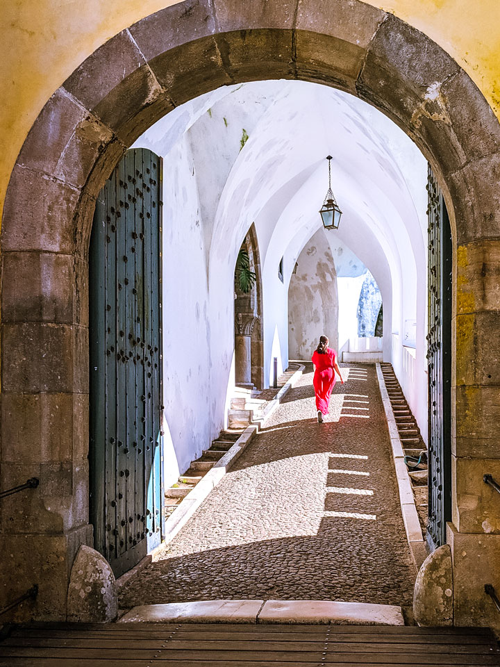 Girl in red dress walking down white tunnel