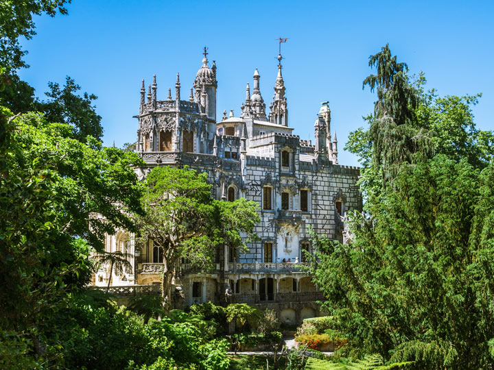 View of Quinta da Regaleira mansion through trees.