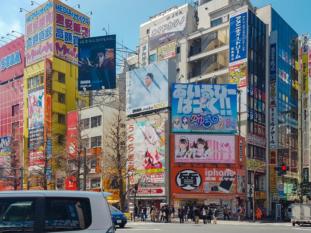 Street view of Akihabara's many colorful billboards and tourists spending 10 days in Japan.