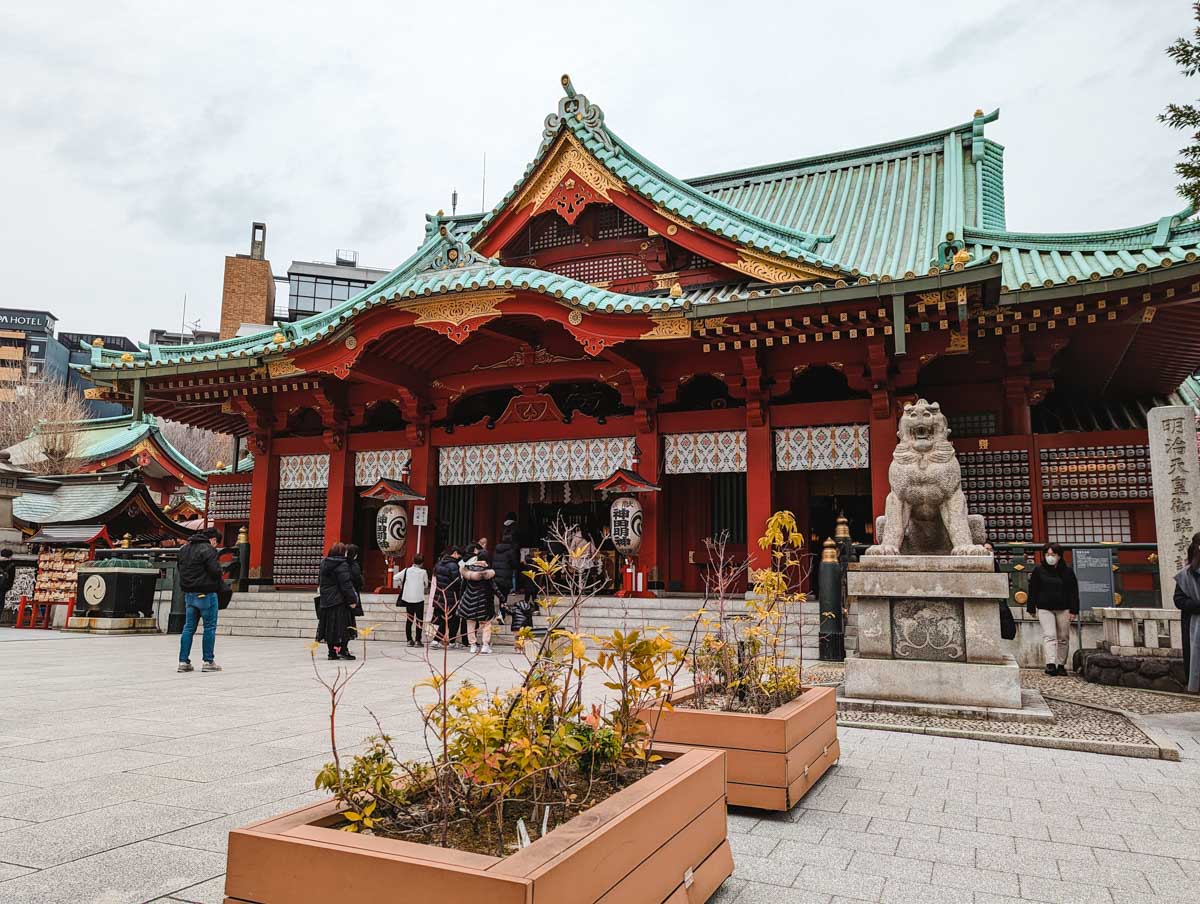 Front of Kanda Myojin Shrine with planter boxes and stone lion statue.