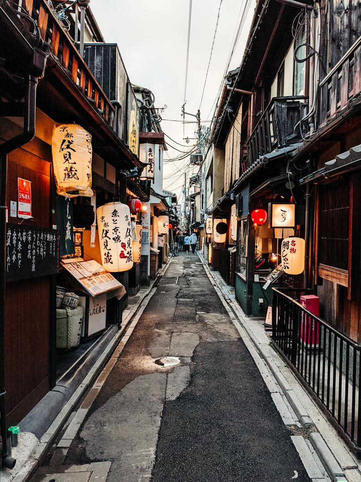 Kyoto Pontocho alley in evening with lanterns and wood facades.