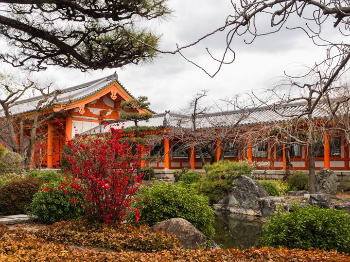 Sanjusangendo temple with autumn leaves and pond.