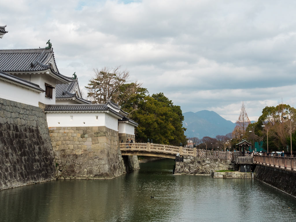 Side view of Sunpu Castle with white exterior and wooden bridge over moat.