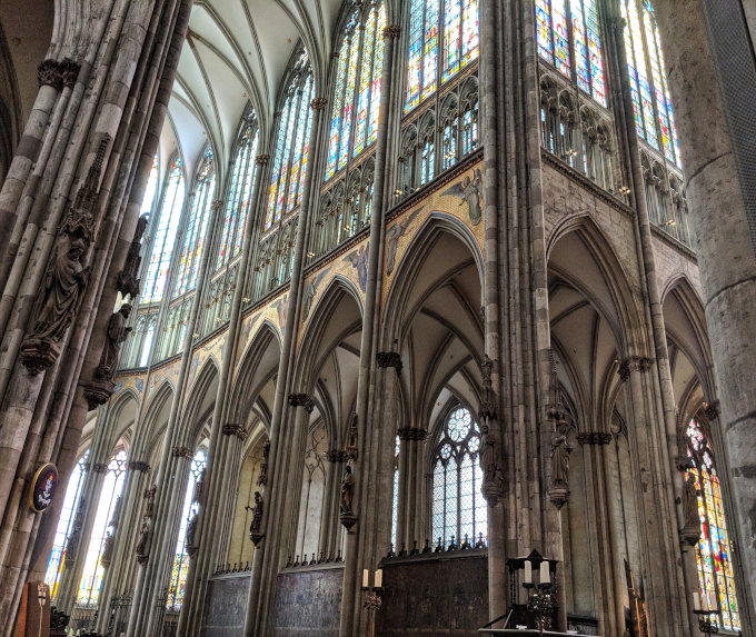 Interior of Cologne Cathedral with tall stained glass windows.