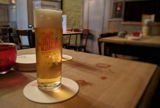 Kölsch glass at Brauhaus Putz on wood table.