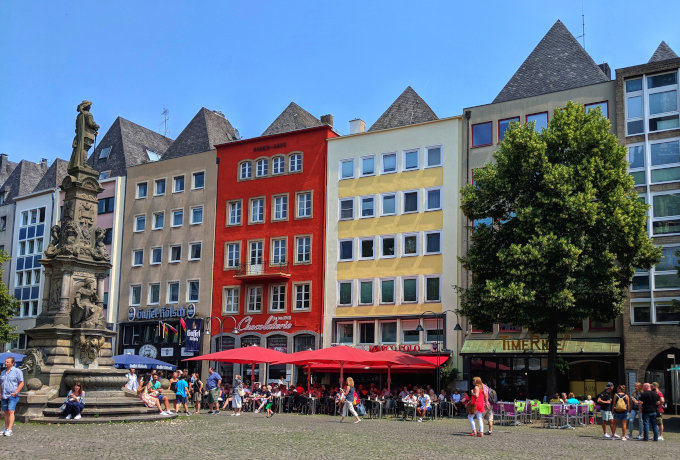 Cologne Old Market (Alter Markt) with red, yellow, and brown buildings.