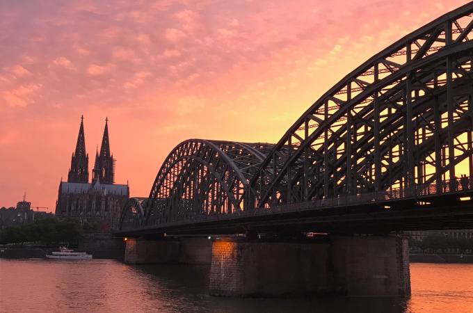 Sunset view of Cologne Cathedral and bridge over river as seen during 2 Days in Cologne itinerary.