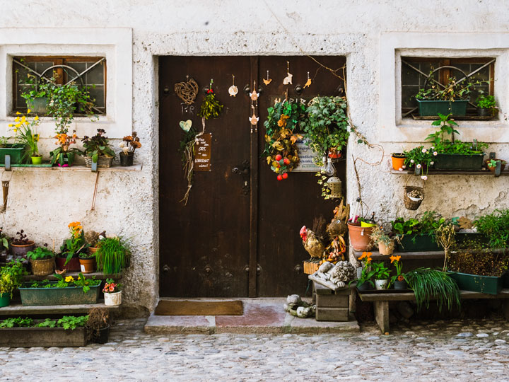 Old stone house facade with brown doors and hanging plants seen during 2 days in Salzburg itinerary.