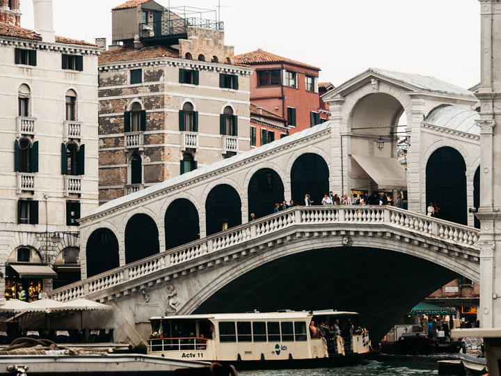 Venice Rialto Bridge with boat passing underneath.