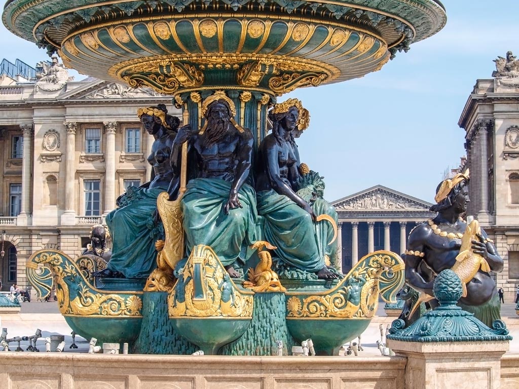 Greek-style statues in green and gold water fountain.