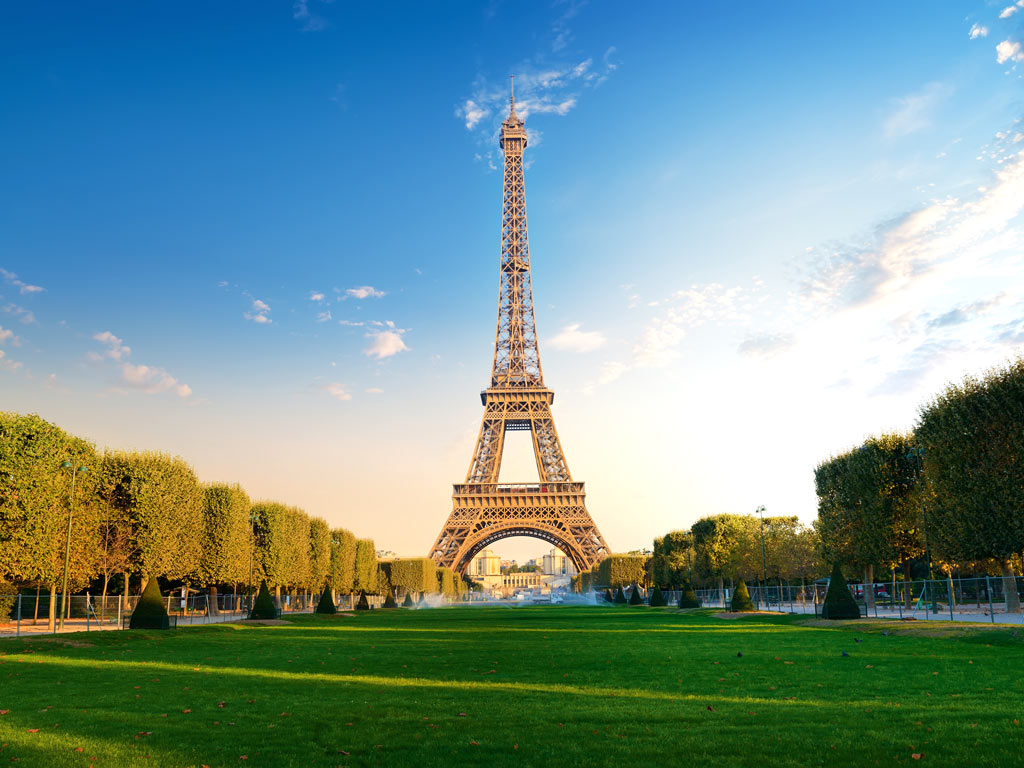 View of Eiffel Tower at sunrise from Champs de Mars park during 4 days in Paris itinerary.