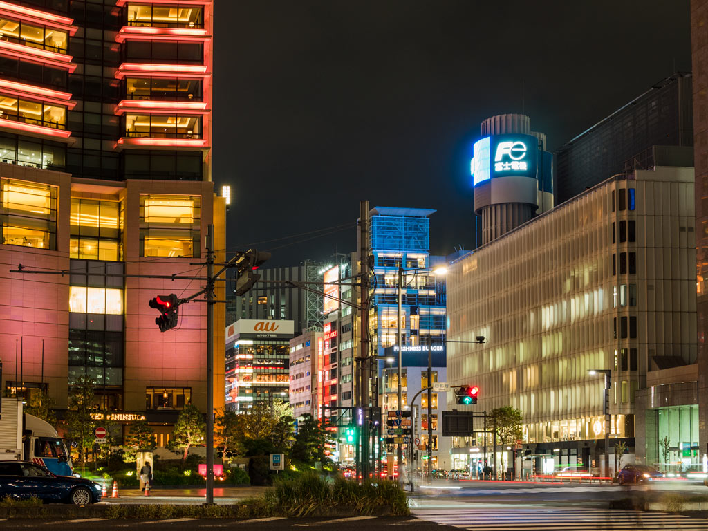 Ginza shopping district at night with illuminated storefronts and crosswalk.