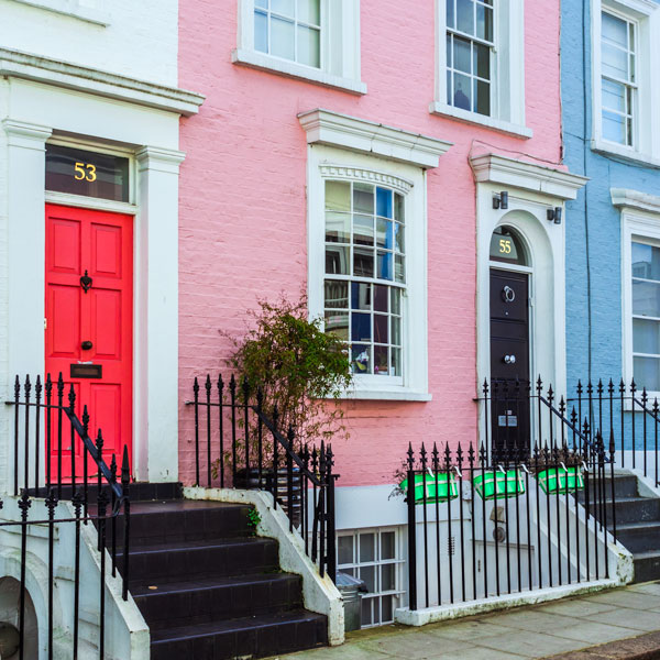 London row homes with pink and black doors and pink facade