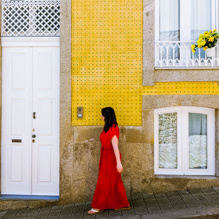 The Portable Wife wearing red dress in front of yellow wall