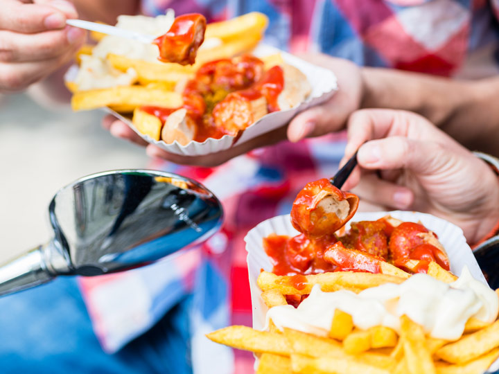 Berlin locals eating currywurst and frites.