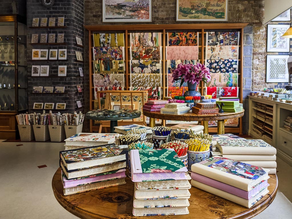 Brightly colored notebooks and pens on table inside Choosing Keeping store in London.