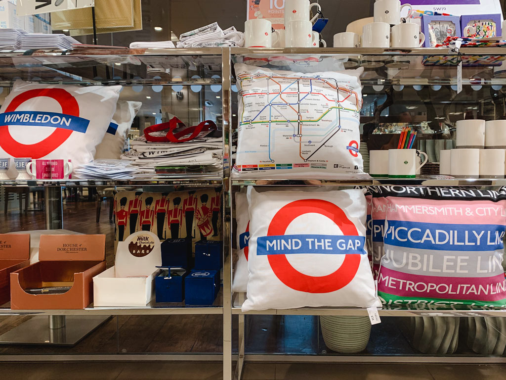 Shelves of London souvenirs including pillows, mugs, tote bags, etc.