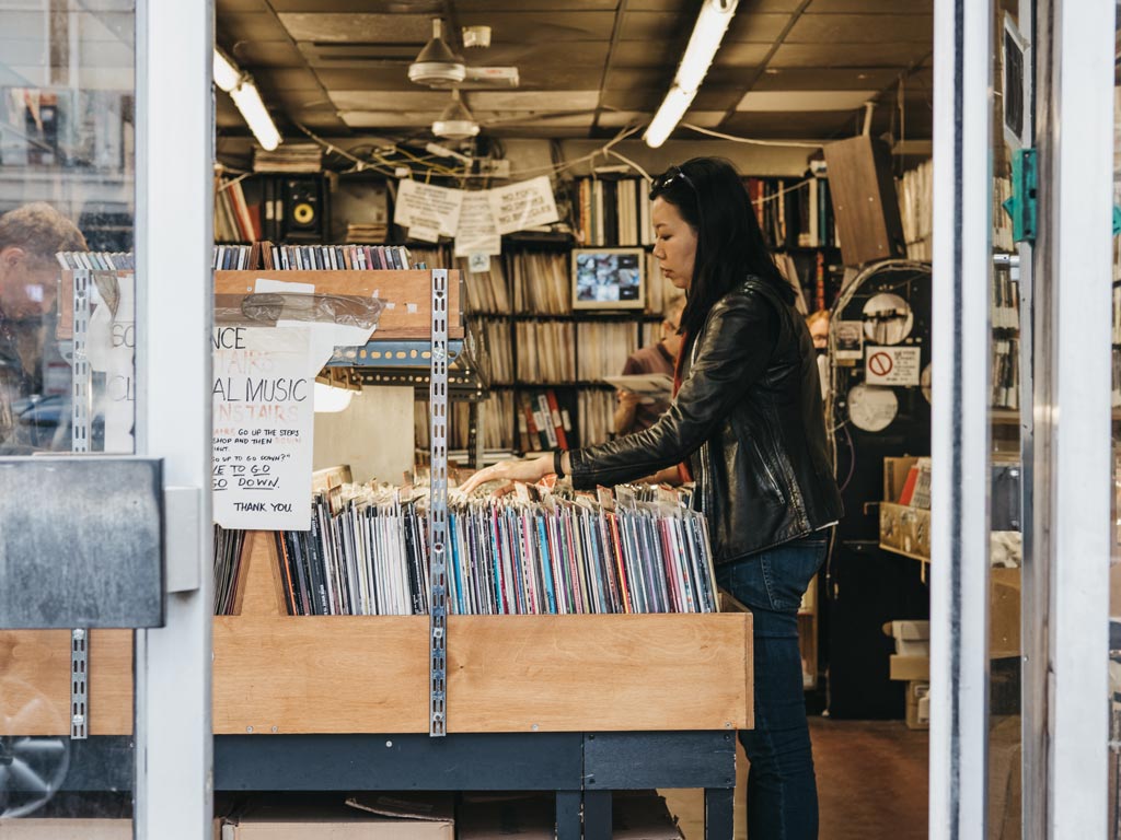 Woman shopping for gifts in London at vinyl record shop.