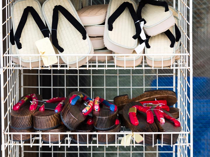 Wire rack holding straw zori and wooden geta sandals.