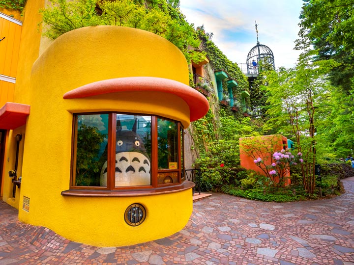 Entrance to Studio Ghiblu Museum with yellow ticket counter and Totoro inside.