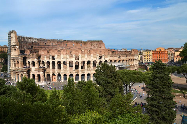 Exterior view of Roman Coliseum on partly cloudy day.