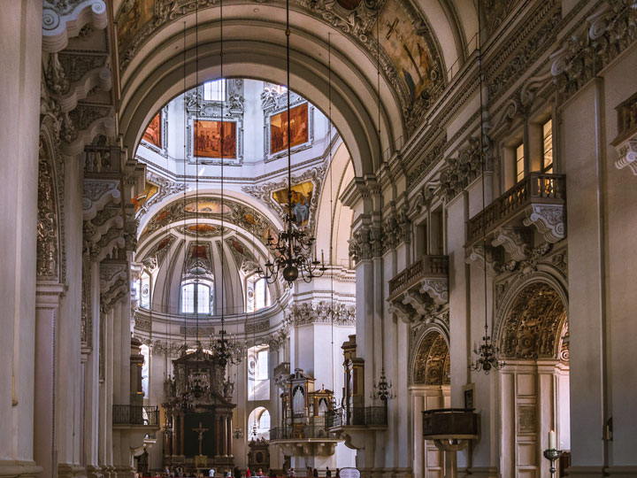 Interior of Salzburg Cathedral with arched vestibule and stained glass.