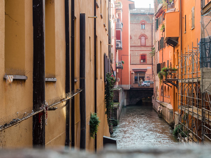 Colorful building canal view across from the Finestrella, a popular place to visit in Bologna.