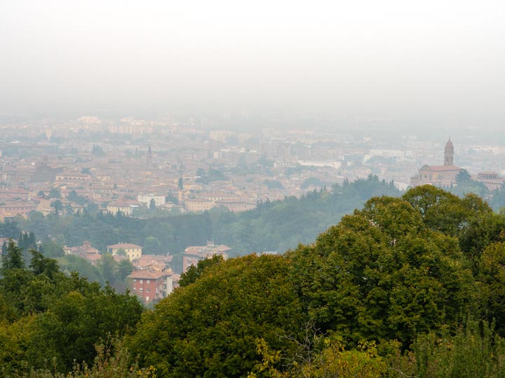 Hazy city view from top of Villa Ghigi Park, a popular Bologna sightseeing spot for panoramic views.