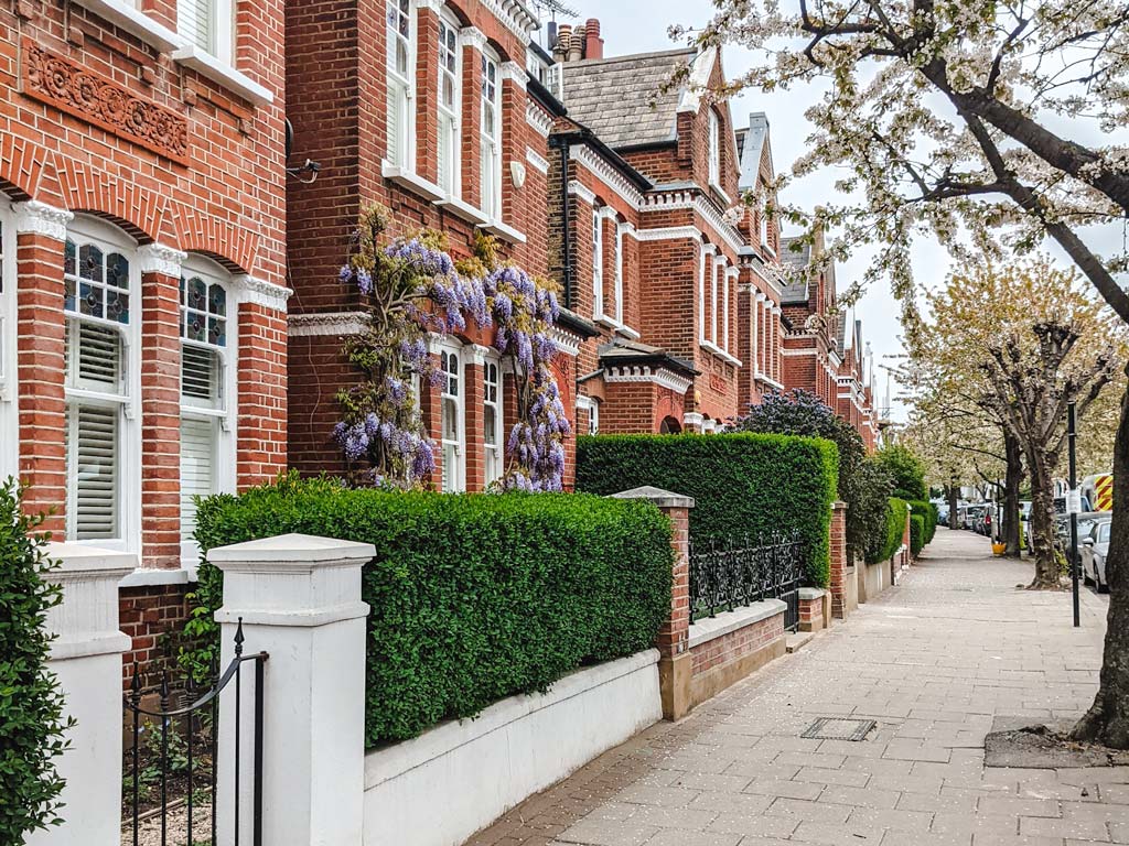 Street with red brick row homes illustrating difference between British vs American houses.