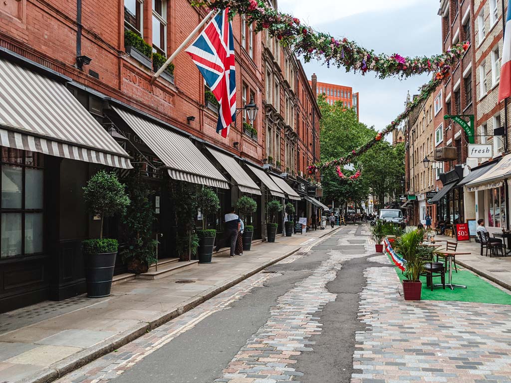 British street with union jack flag and garland hanging from buildings.