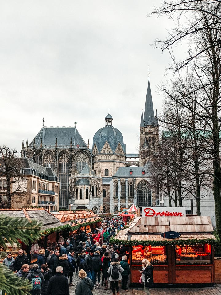 View of Aachen Christmas market stalls with cathedral in background.