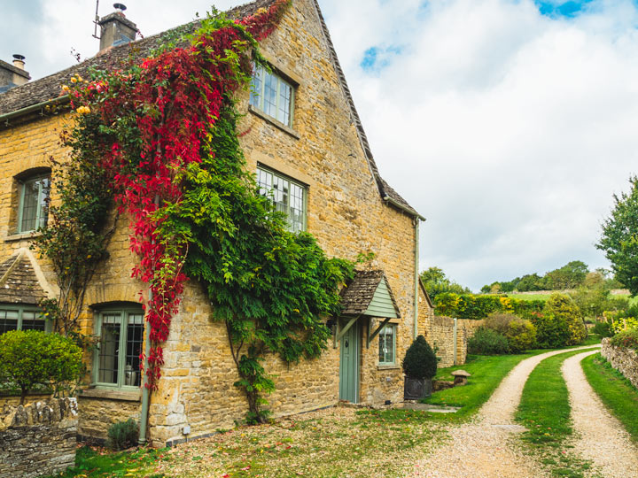 Cotswolds day trip itinerary house stay with red and green ivy growing on side.