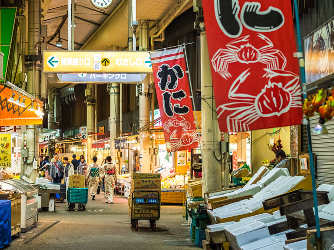 Omicho Market lit up at night and lined with food stalls, final stop of the Kanazawa itinerary.