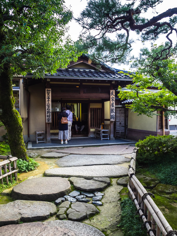 Exterior of Nomura Clan Samurai House with two women waiting to enter.