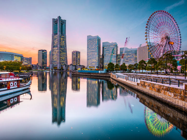 Yokohama Minato Mirai district with skyscrapers and ferris wheel reflected in water.