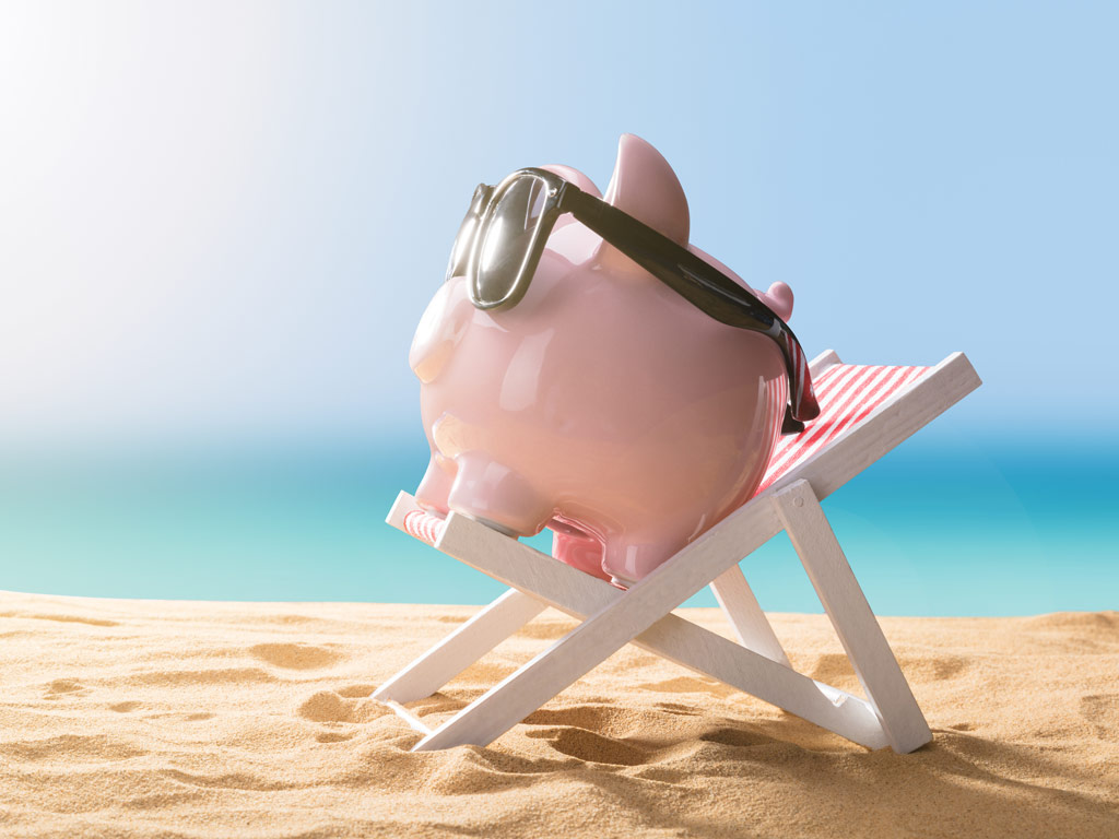 Piggybank sitting on beach chair being used to grow travel fund.