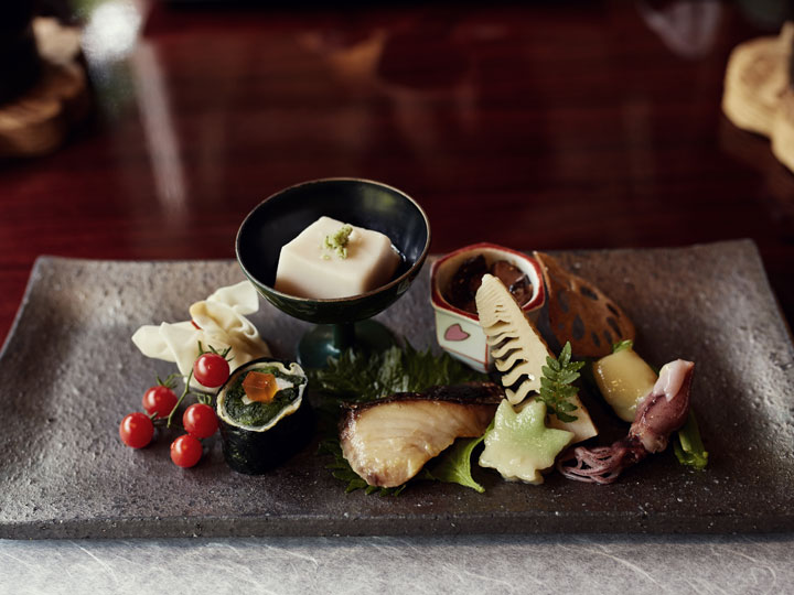 Assortment of Japanese dishes on platter for kaiseki meal.