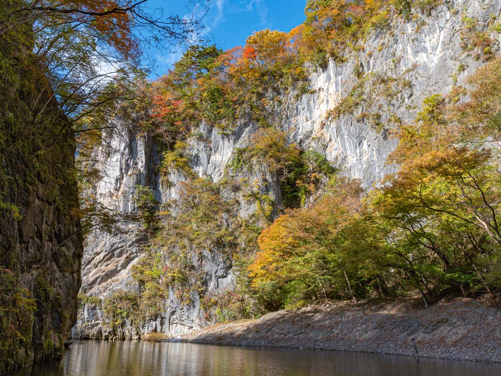 Autumn view of trees and white cliff sides of Geibikei Gorge.