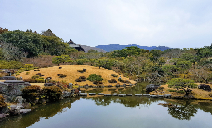 Japan traditional garden pond with mossy hills.