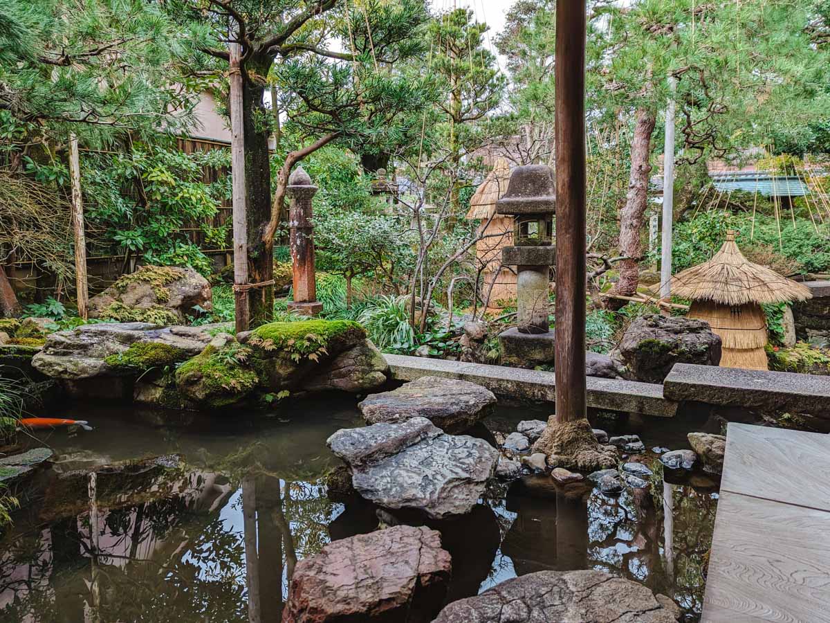 Traditional Japanese garden with koi pond and pine trees inside Nomura Clan Samurai House.