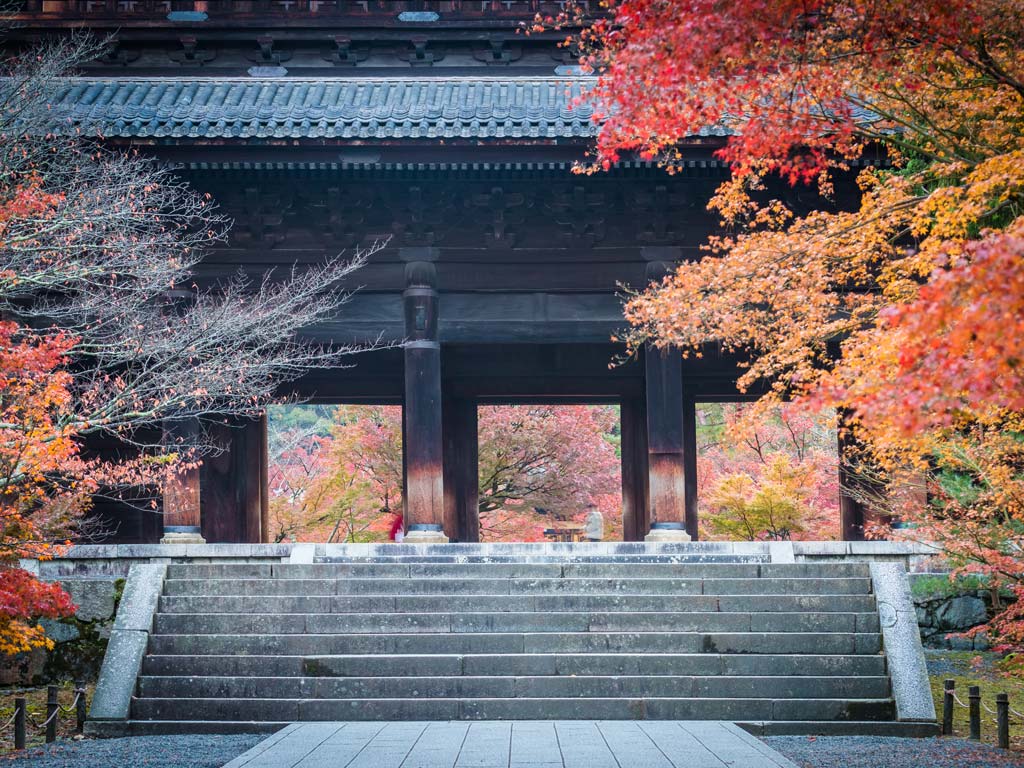 Nanzenji temple gate with autumn leaves framing sides, a must see during a Kyoto 2 day itinerary.