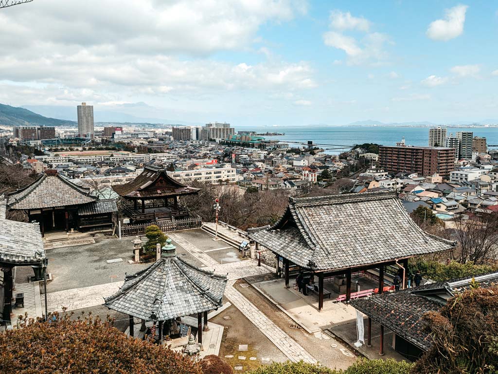 Mii-dera shrine viewed from a hill overlooking the roofs, along with cityscape and Lake Biwa.