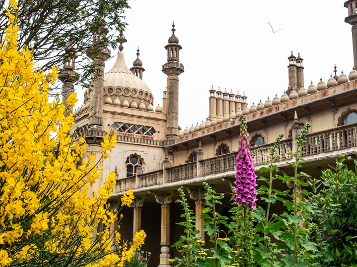 Brighton Palace balcony and tower with yellow and purple flowers in foreground.