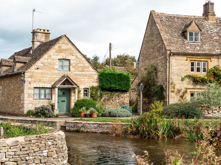 Living in England pros and cons include visits to this beautiful Cotswolds stone cottage on a canal.