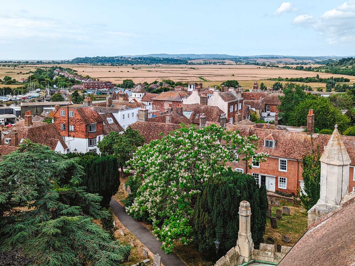 View over town of Rye, England with old brick houses and fields in distance.