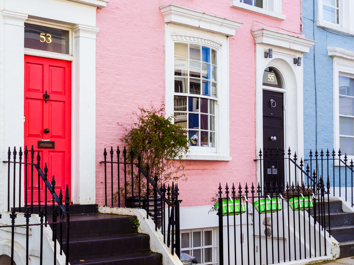 London row homes with pink and blue facades and pink and black doors.