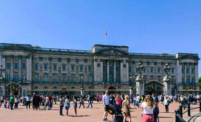 Front of Buckingham Palace with tourists walking around.