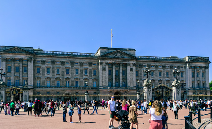 Front of Buckingham Palace with lots of tourists walking outside.