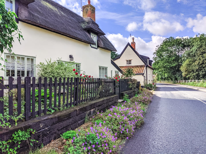 Thatched roof cottages with flower garden on street in Debenham Suffolk.