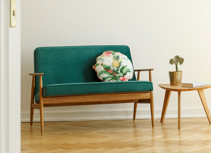 Living space decorated with sofa, end table, throw pillow, and book on minimalist lifestyle tips.